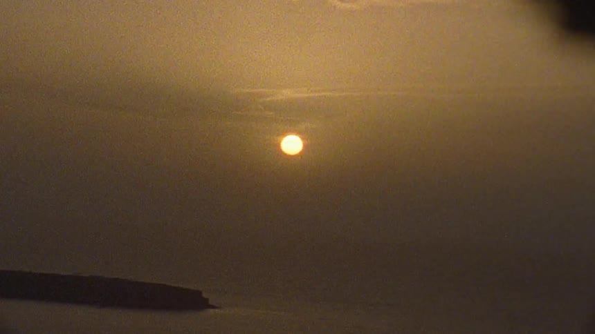 The sun sets over a body of water