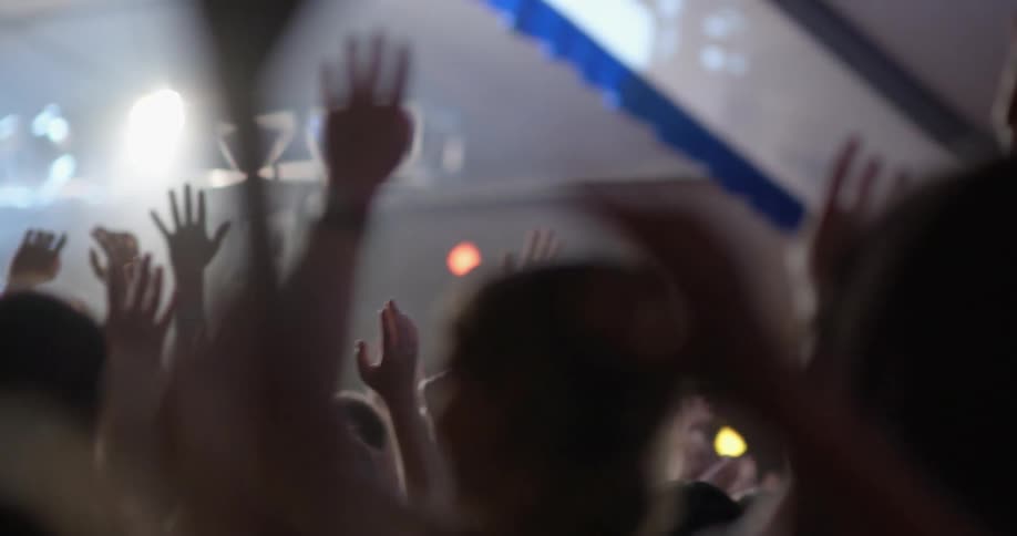 The fans raise their hands for the performer
