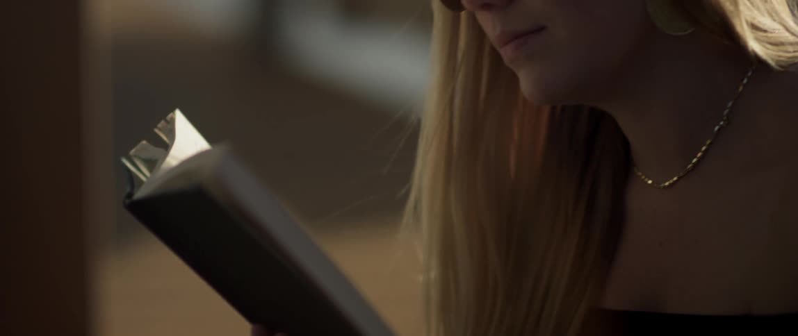 A woman sits outside reading a book