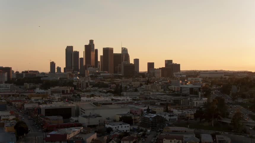 Skyscrapers and buildings in city at sunset