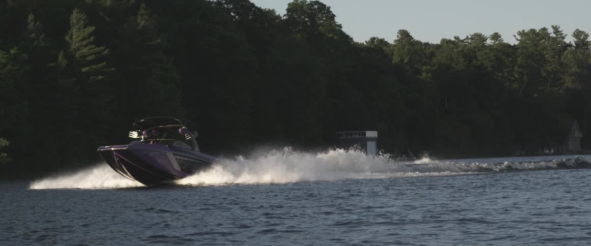 A boat is speeding through a lake