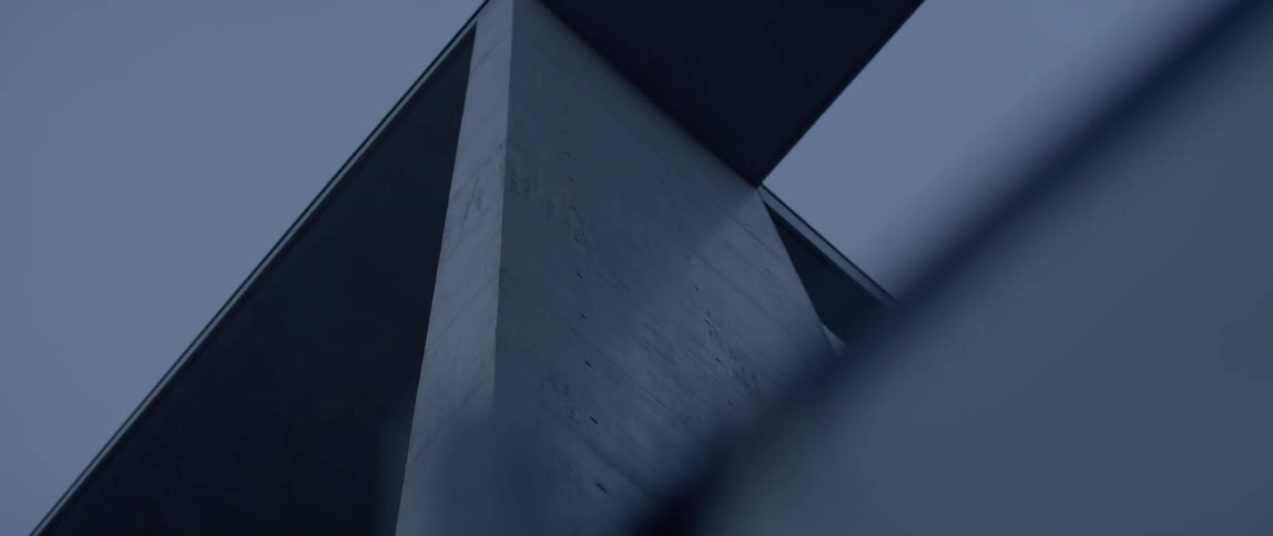 Concrete beams hang above on an overcast day