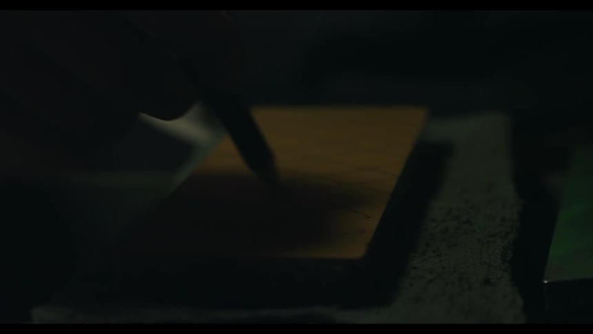 A piece of wood is being marked with a pencil