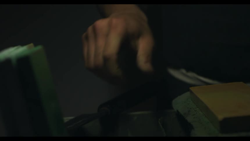 A guy is picking up a knife to sharpen