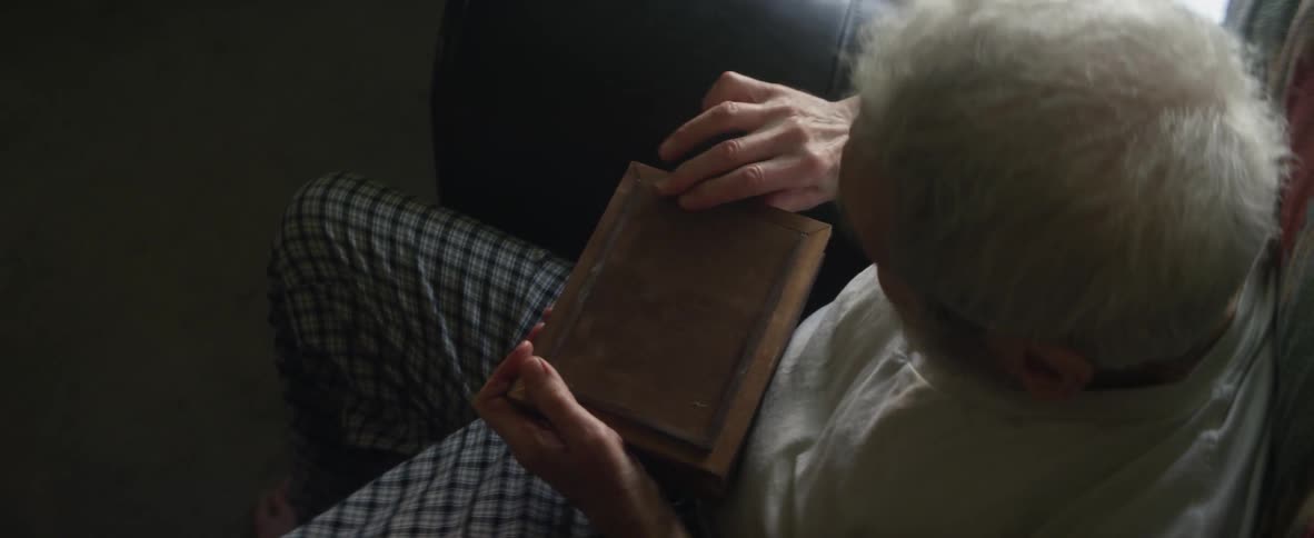 A man holds and opens a photo frame of wedding photographs