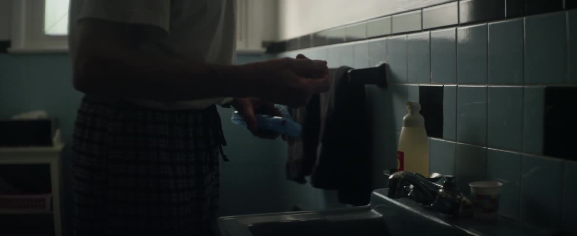 Someone is washing their teeth when they find something in the bottom of the sink