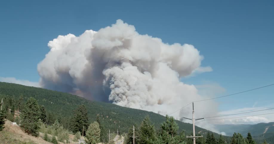 Smoke billows from behind a hill