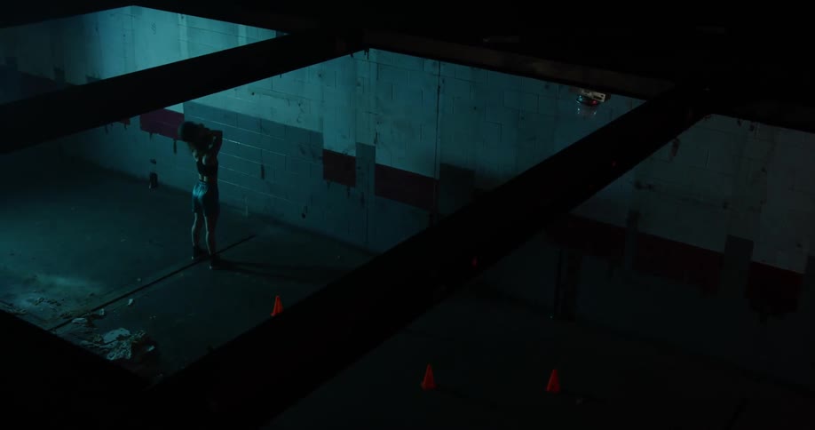 A woman bounces a basketball off the wall