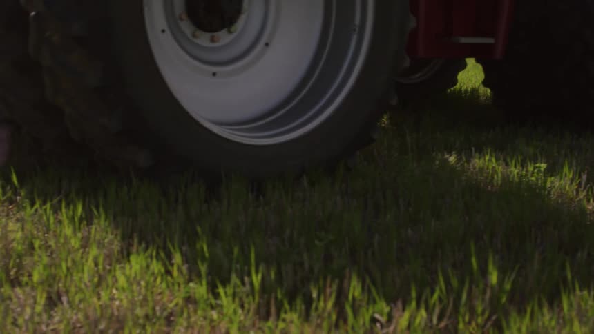 A tractor is rolling over a grassy field