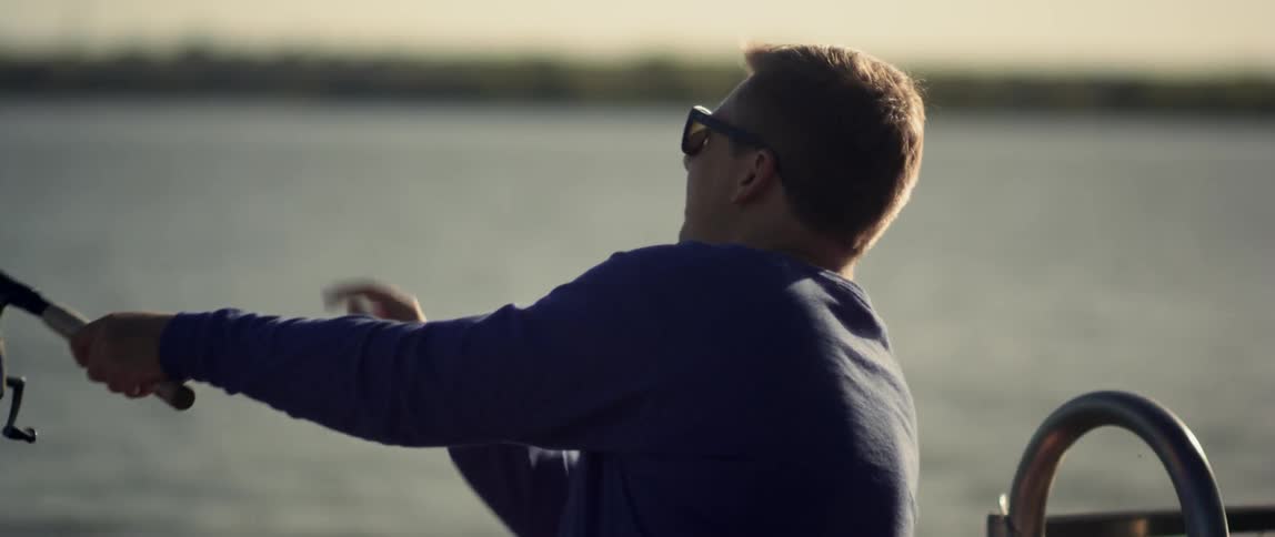 A man casts a fishing line into the water