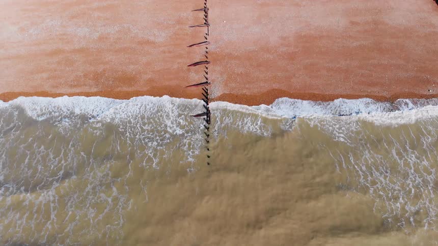 The beach shoreline is being filmed from a drone