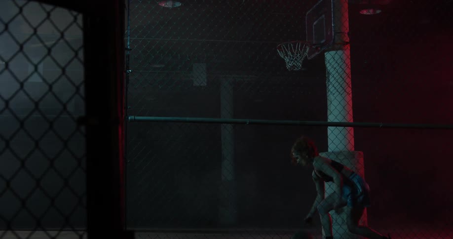 A woman dribbles a basketball between her legs