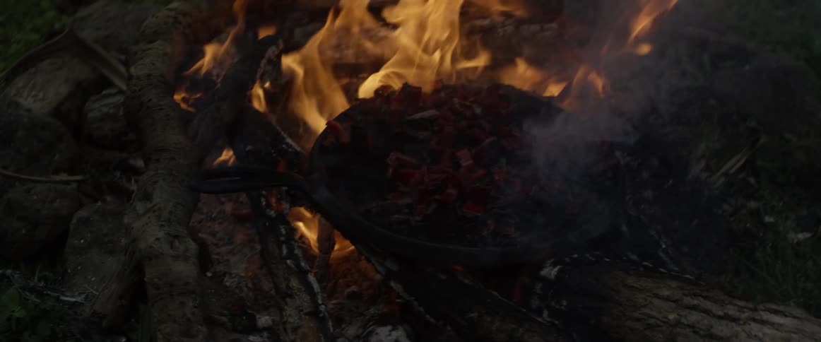 A pan of food is cooking inside a fire