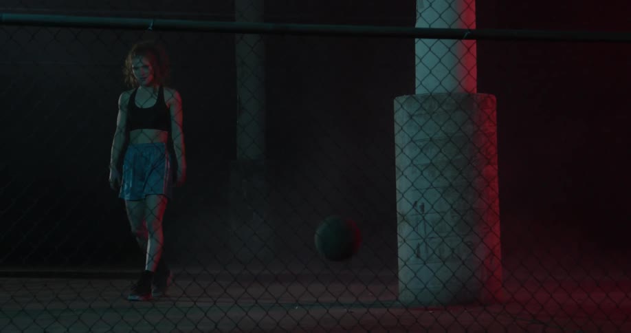 A woman kicks a basketball in frustration