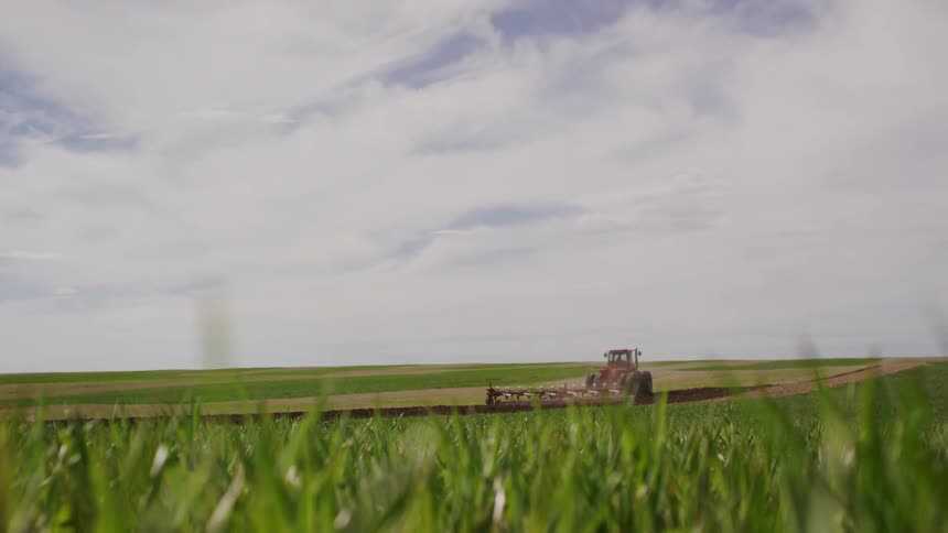 A farm vehicle works the land ahead