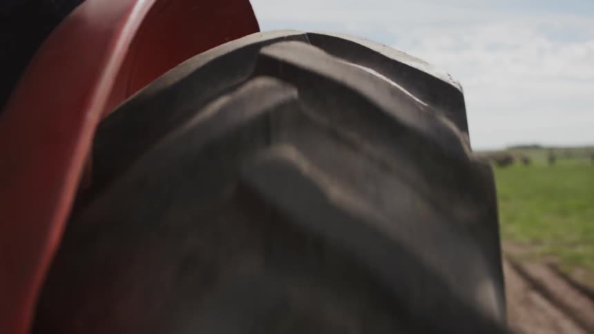 A tractor plows across the land