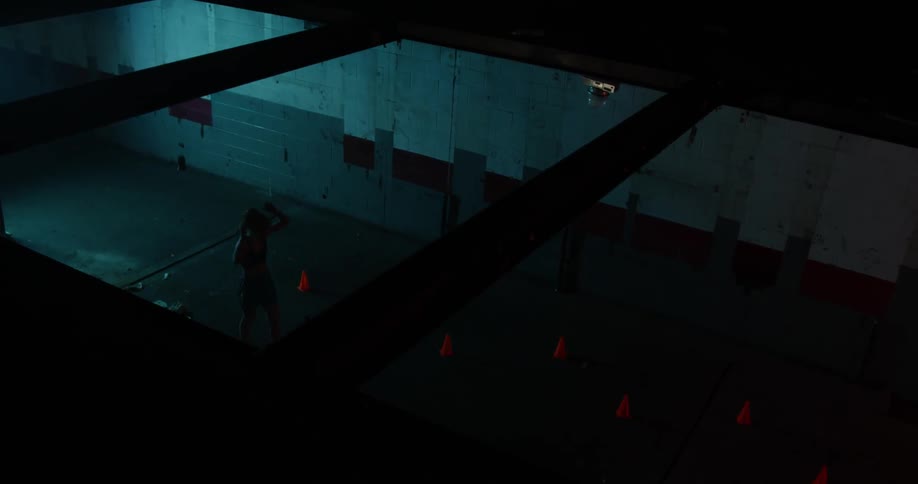A woman kicks a ball at the wall then paces