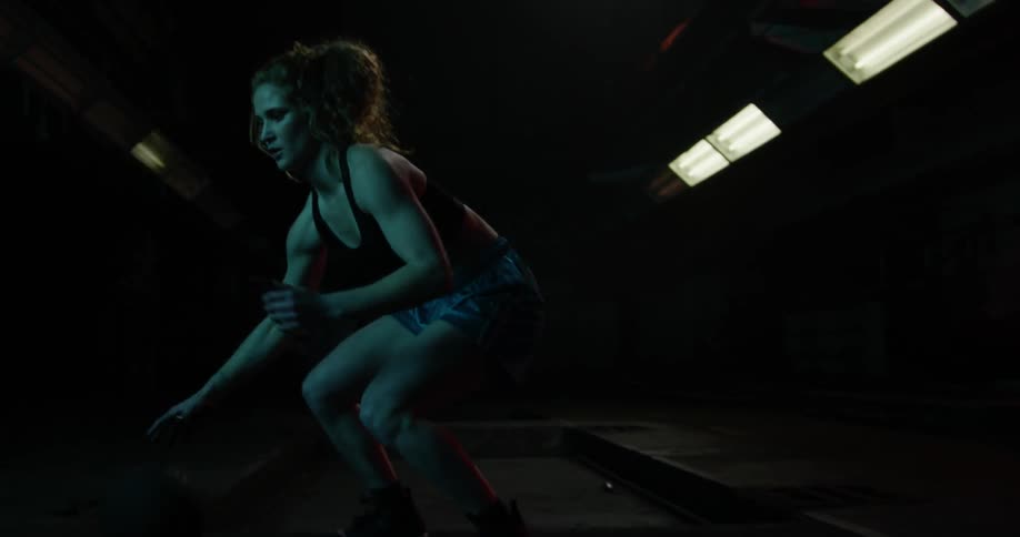 A woman dribbles a basketball between her legs