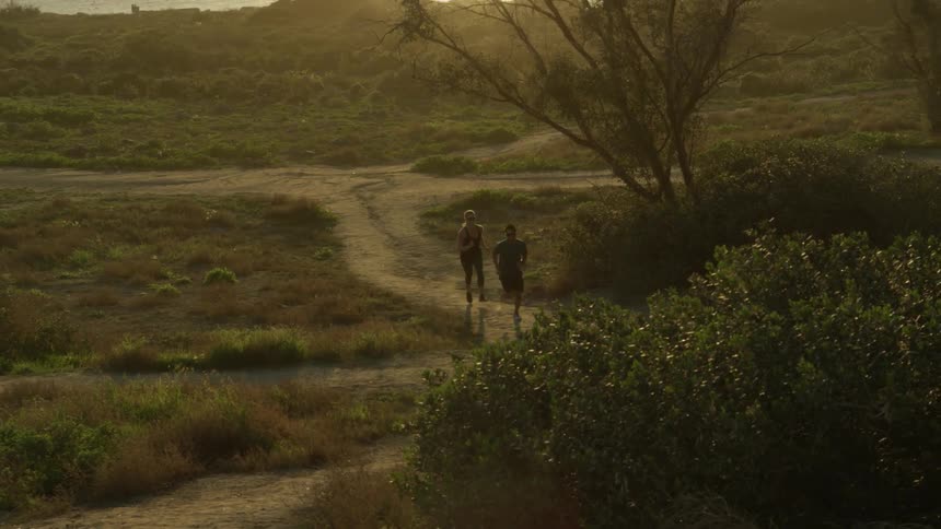A group of people run along a dirt trail