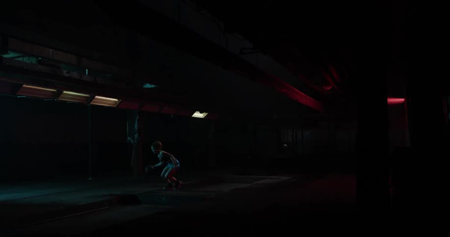 A woman is dribbling a basketball in a dark alley