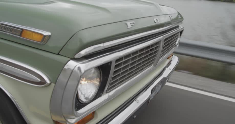 An old pickup truck is driven next to a lake