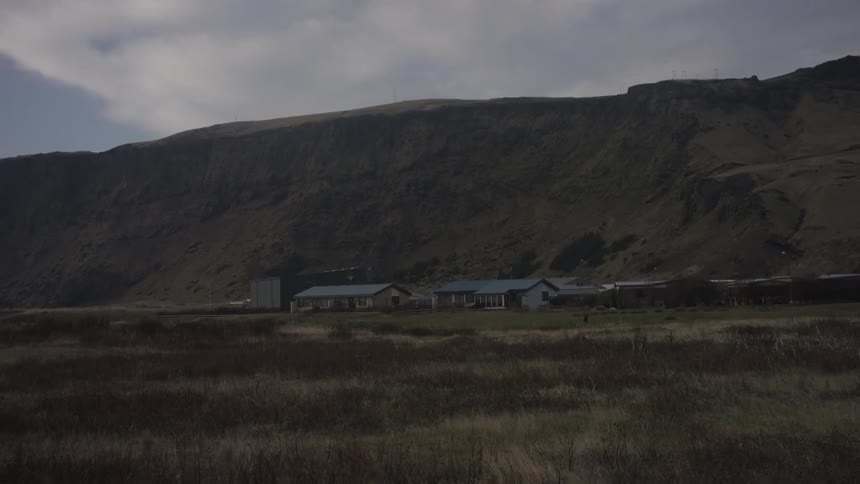 A farm near a mountain on an overcast day