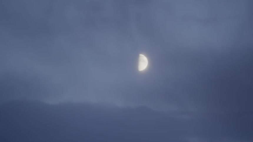 The half moon in a cloudy sky