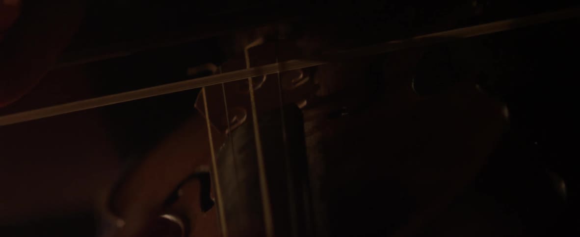 Bow being pushed across violin strings