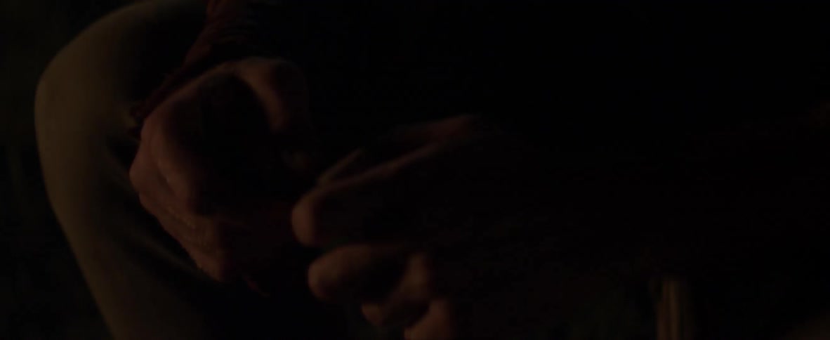 A man is playing with a piece of wood in his hand