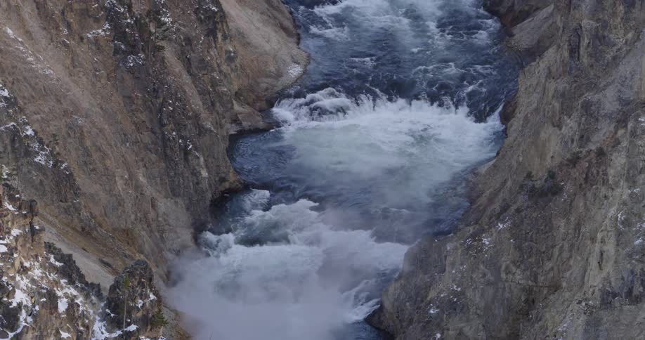 A river gushes over rapids in a rocky canyon