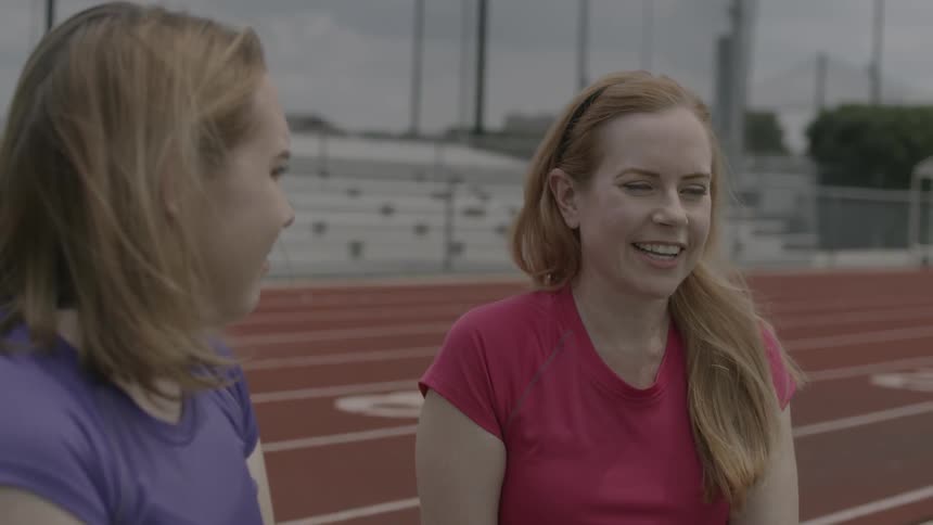 Two women talk with each other and laugh