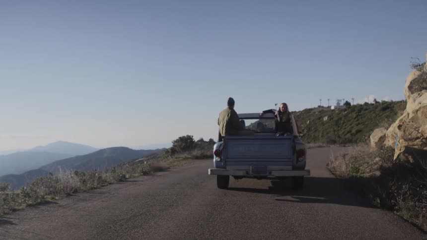 People ride in a truck on a mountain road