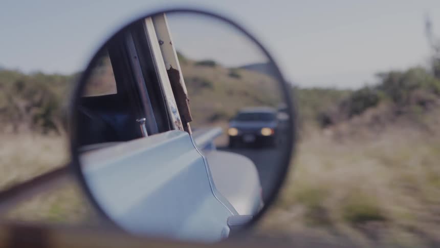 Looking at the vehicles behind through a rear view mirror