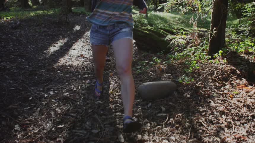 Two people jog in a forest
