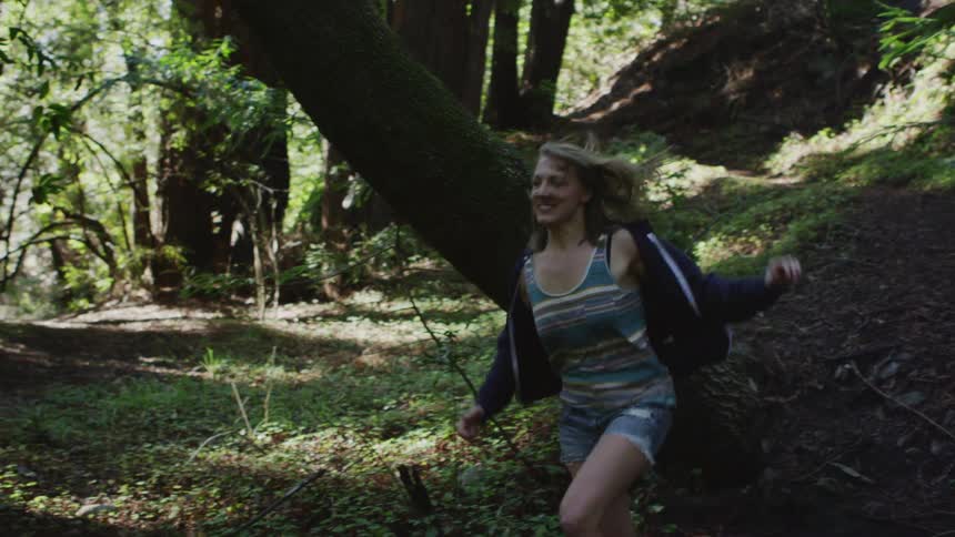 Two people run through the woods