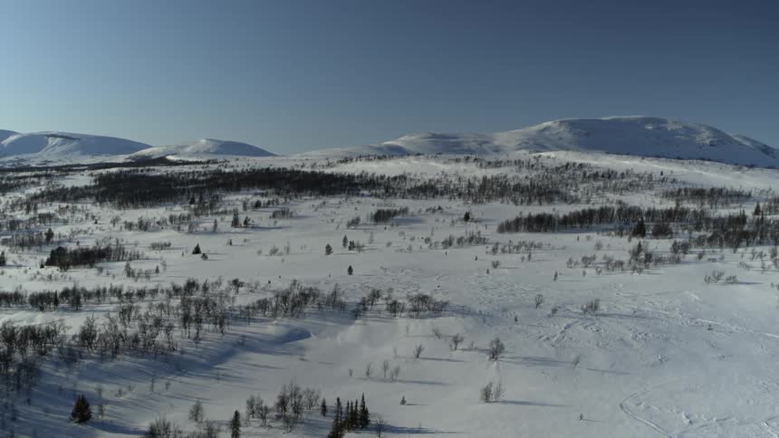A drone is filming a snow covered landscape