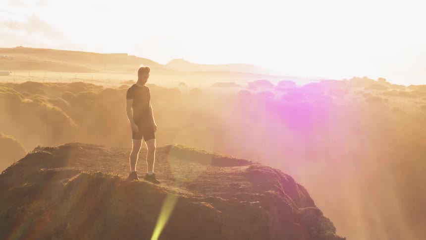 Man stands on a cliff on a sunny day