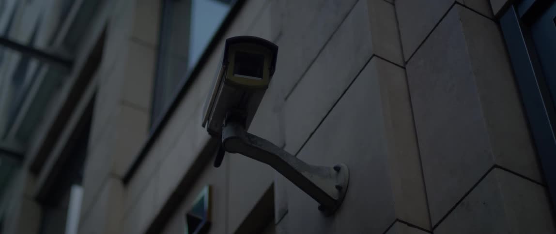 A security camera is attached to the exterior of a building