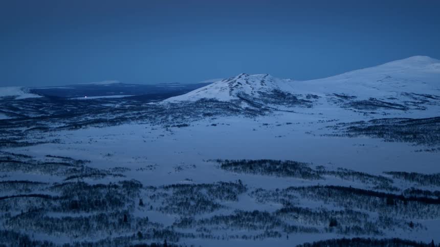 A drone is filming a snow covered landscape