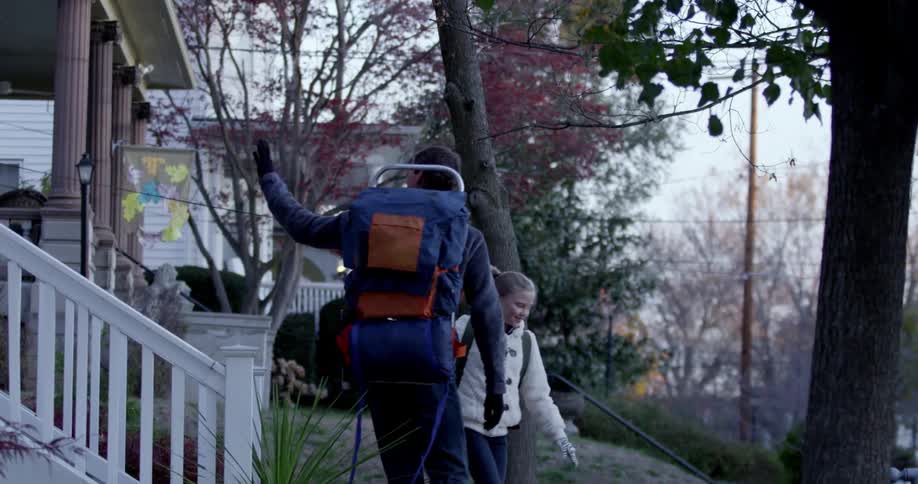 Two kids walk down the front steps and wave