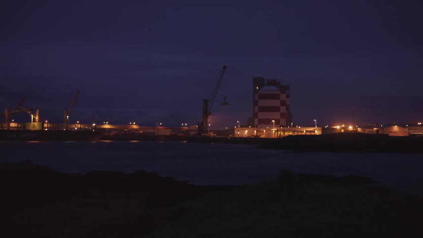 A port is shown from a far at night