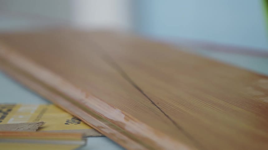 A man is marking a piece of wood for cutting