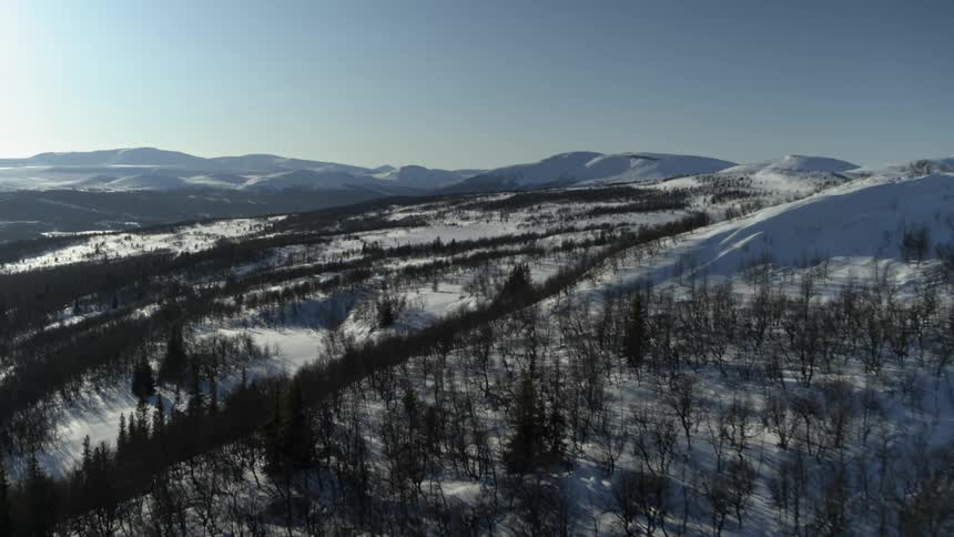 Snowy mountains are shown on a sunny day