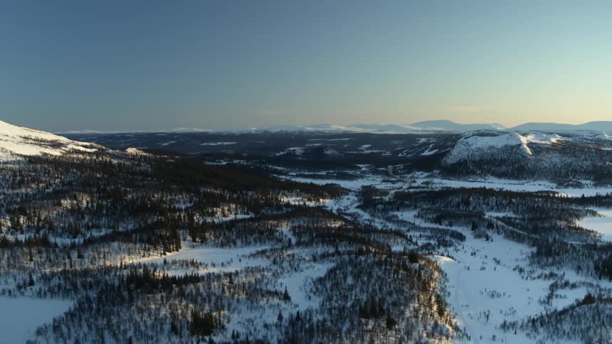 The sun sets over snowy mountains