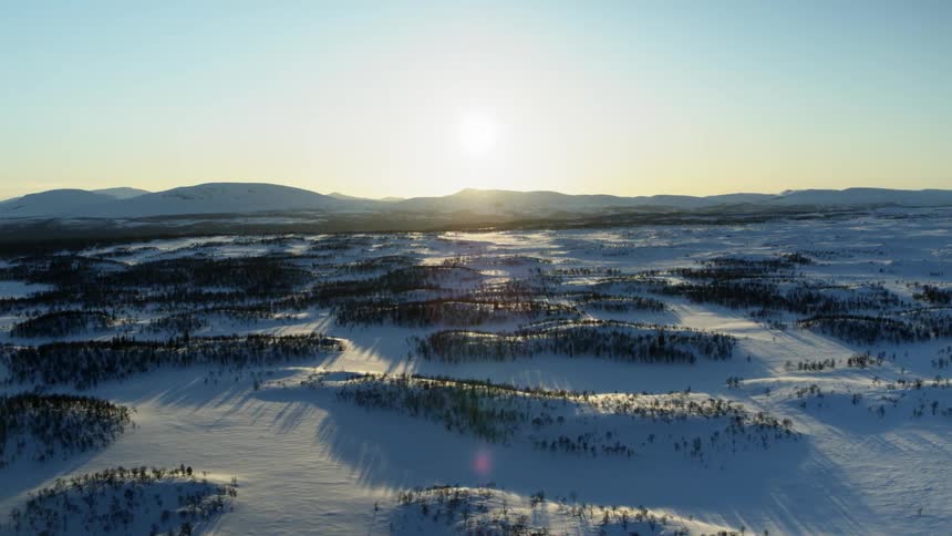 The sun sets over snowy mountains