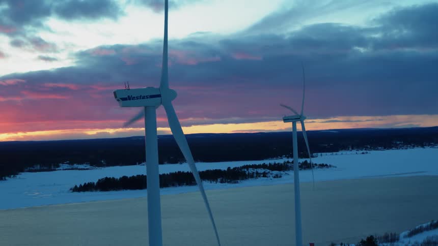 Wind turbines rotate at sunset