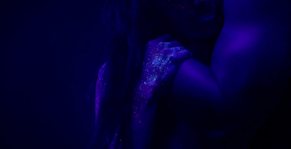 A man and woman with body paint on dance in UV light