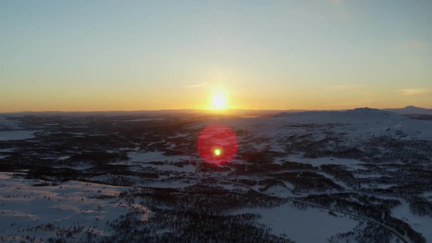 The sun sets over snowy mountains