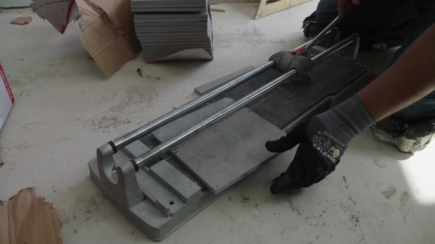A man is cutting tile