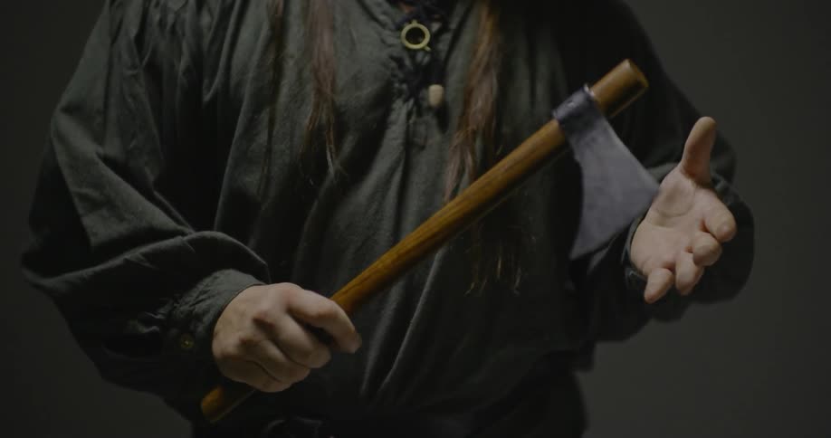 A man is rubbing the tip of his axe